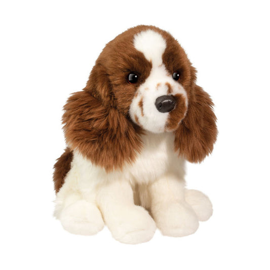 This is Chip by Douglas Cuddle Toys. Chip is a sitting spaniel with long, shaggy brown fur on the head and ears and shorter, dense white fur on the body, tummy and paws; the fur has a soft sheen and appears plush. The muzzle is white with small brown speckled markings, the nose is black and rounded, and the eyes are black and set symmetrically in the brown face. The inner ear areas match the brown fur. Four white paws are visible in a seated pose. The plush is not jointed and holds a relaxed, gentle ex...