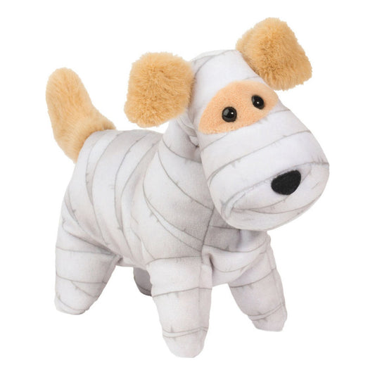 This is Mummy Dog by Douglas Cuddle Toys. Small standing dog with short, smooth, dense plush fur that has a slight sheen; the main body fur is white with gray bandage-like stripes running around head, body and legs. Ears, tail and the eye-area muzzle patch are beige and appear the same short, fluffy texture as the rest of the fur. Tummy and paws are white with gray striping matching the body. Eyes are black and round. Nose is black and oval. No separate markings beyond the gray striping. The plush is i...