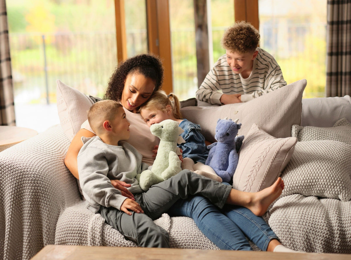 Family on the sofa with Stevie Stegosaurus and Draco Dragon