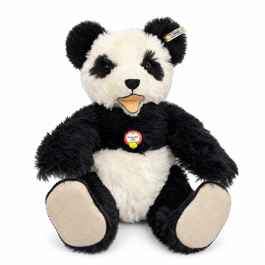 This is Panda Bear 1951 Replica by Steiff. Large panda with a shaggy, medium-length fur that appears slightly lustrous and dense. Fur colours are black on the ears, eye patches, arms, legs and shoulders, and white on the face centre, tummy and inner chest; paw pads and the visible sole areas are beige. Muzzle is white with a small black triangular nose and a short black vertical stitch down from the nose. Eyes are dark brown and set within black eye patches. Mouth is open showing a beige/orange tongue ...