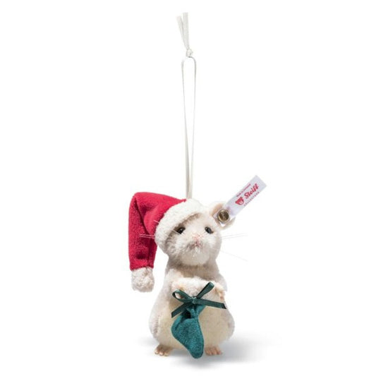 This is Christmas Mouse by Steiff. Small handcrafted mouse made of mohair with short, slightly curly, dense fur and a low sheen; fur is mainly white with a beige patch on the tummy and subtle pink in the inner ears and paw tips. The mouse sits upright, not jointed, holding a small green stocking; it also wears a red Santa hat trimmed with white. Eyes are black and round, the nose is small and pink and triangular, and fine whiskers radiate from the muzzle. Small beige paws are visible at the base. The p...